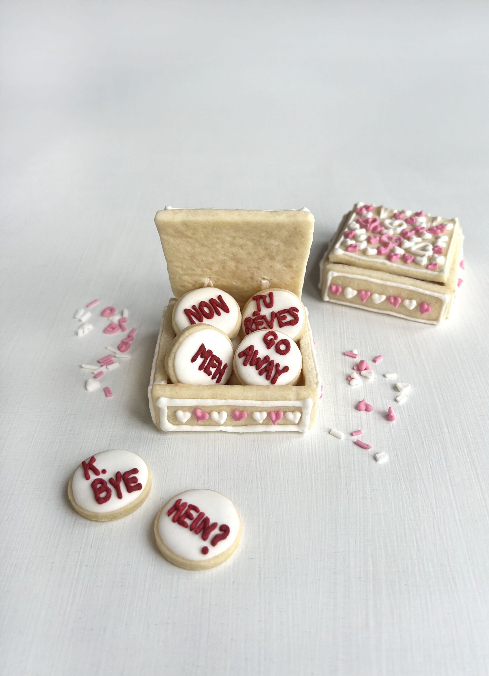Close-up of sugar cookies with heart cut-outs and playful sassy wording.
